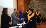 Egresada de la licenciatura en Gestión Cultural recibiendo la documentación de manos del presídium