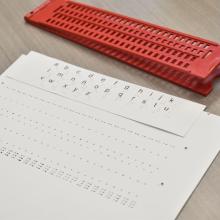 regleta y hoja con ejercicios de la clase de braille