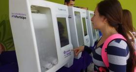 Mujer realizando su voto en urna electrónica