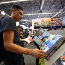Hombre hojeando libro en FIL