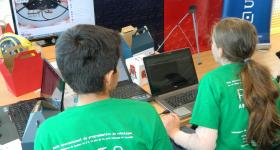Niños trabajando frente a computadora de escritorio, en el proyecto R2T2